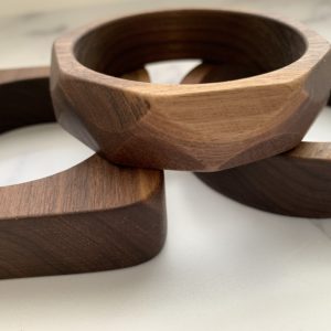 Pile of Vannucchi Jewellery walnut bangles, with focus on the Maria multi angled walnut bangle on top