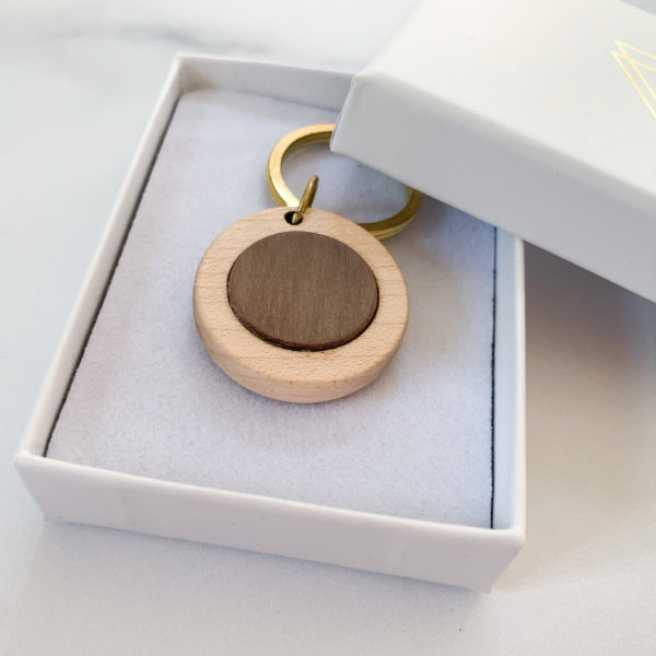 Pale white wood round key ring with walnut inlay, displayed in Vannucchi Jewellery branded box