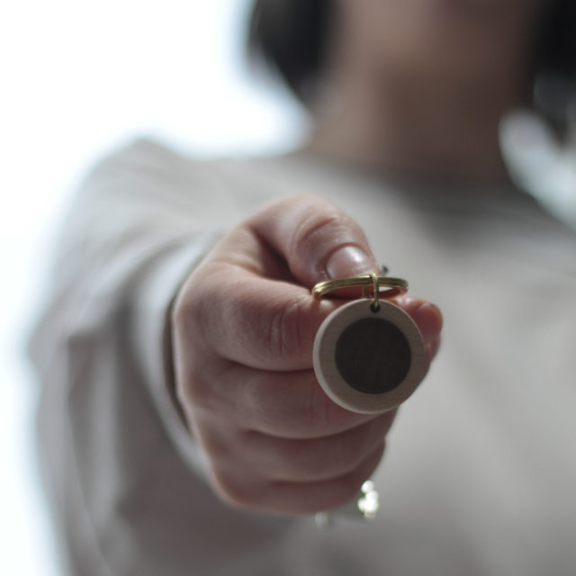 Vannucchi Jewellery model holds out maple and walnut pebble key ring