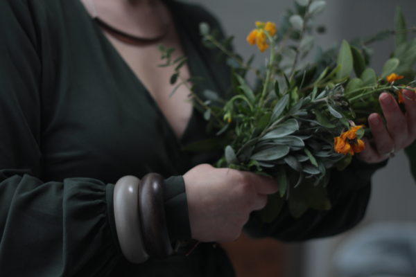 Vannucchi Jewellery Model holds bouquet of wild garden flowers and wears brown Dare necklace and two of the Pamela Bangles in brown and grey