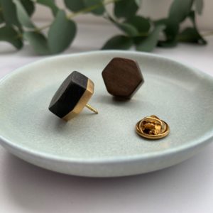 Brown and black Vannucchi Jewellery wood with brass hex pins displayed in aqua coloured dish