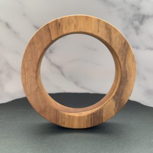 Vannucchi Jewellery's Ruth olive wood round bangle stood upright on slate