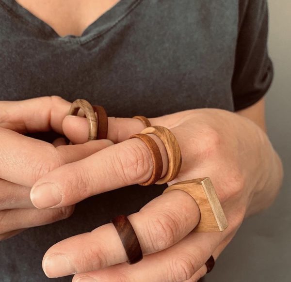 Vannucchi Jewellery's hand model wears a collection of different wooden rings