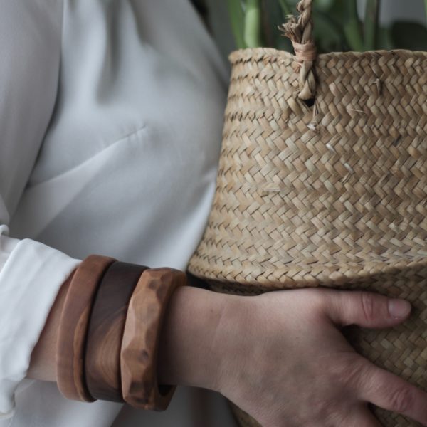 Vannucchi Jewellery's model wears three wooden bangles whilst holding a basket