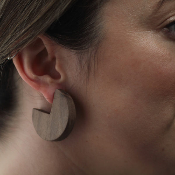 Close up of Vannucchi's Ellie, walnut wood, sector shaped earring