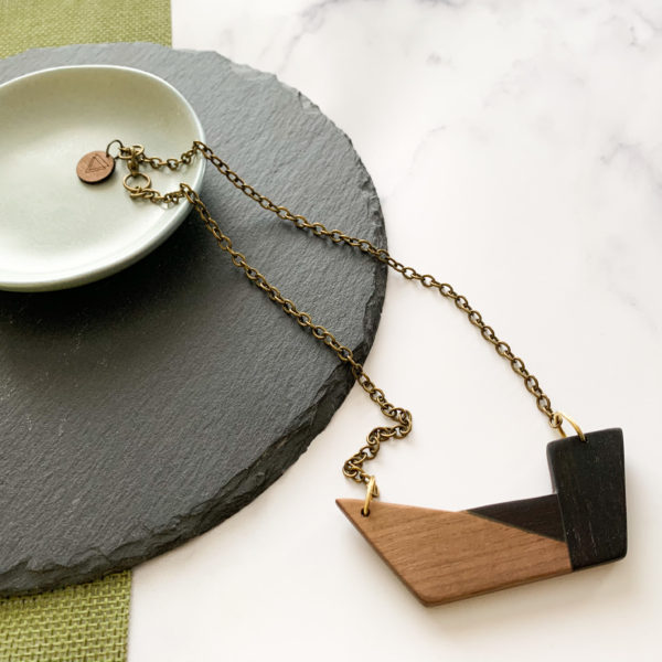 Vannucchi Jewellery Chiaro wood necklace displayed draped at angle over aqua coloured dish on slate