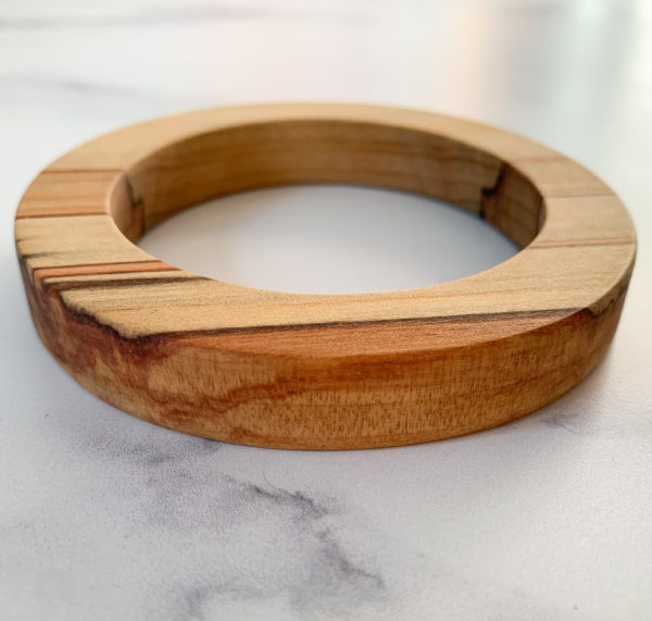 Close up shot of red colours running through Sara parana pine wood bangle created by Vannucchi Jewellery