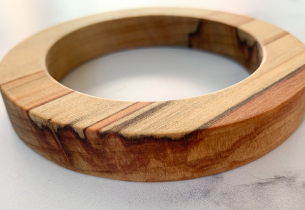 Close up shot of red colours running through Sara parana pine wood bangle created by Vannucchi Jewellery