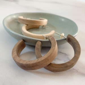 Display of Vannucchi Jewellery, Sarah maple and walnut wooden hoop earrings in aqua coloured dish