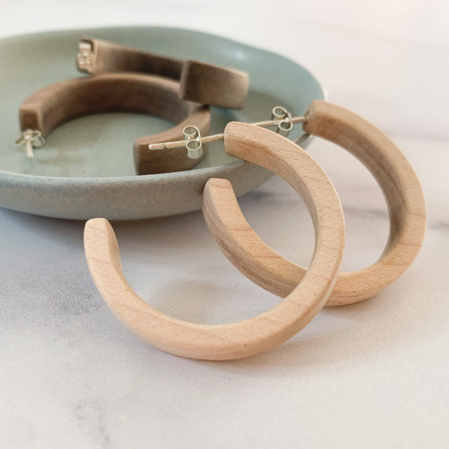 Display of Vannucchi Jewellery, Sarah maple and walnut wooden hoop earrings in aqua coloured dish