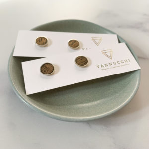 Two pairs of Vannucchi Jewellery Suzi, silver and oak studs on aqua coloured dish