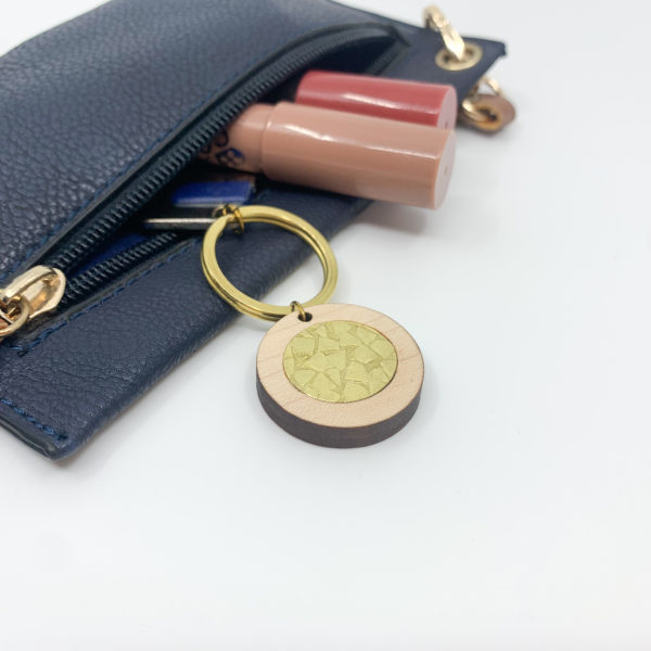 textured brass and wood keyring in purse with lipsticks
