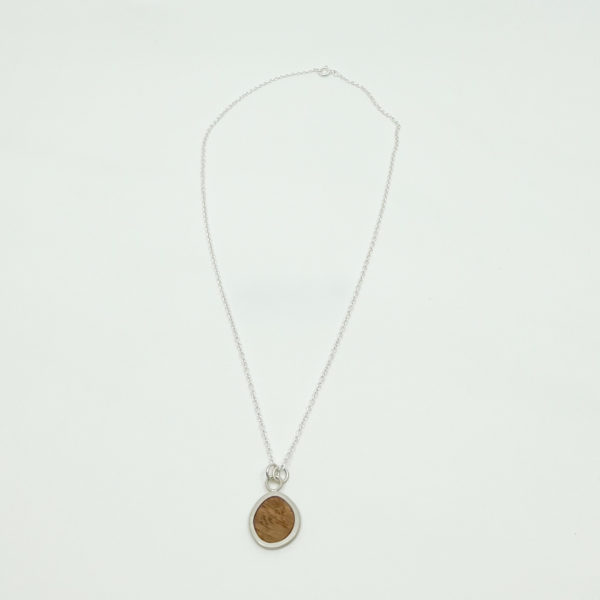 Collezione XXI Oak Pebble Necklace displayed on white background. Long fine silver chain with pebble shaped pendant made from silver and oak.