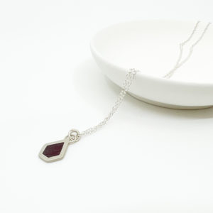 Collezione XXI Purple Heart necklace;ace is displayed on white background, laid over a white dish.