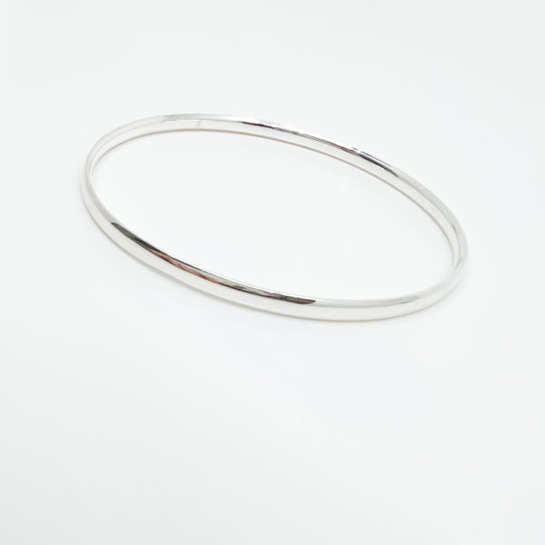 Highly polished collezione XXI bangle displayed on white background