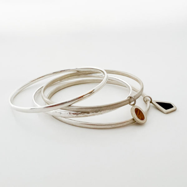 Stack of Collezione XXI bangles on white background.