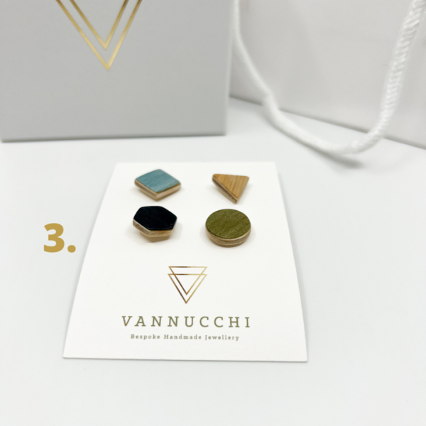 Mix and Match Veneer Pin Set three, four geometric shaped wood pins, with light blue, olive green, light oak and black veneers. Displayed on white Vannucchi backing card.