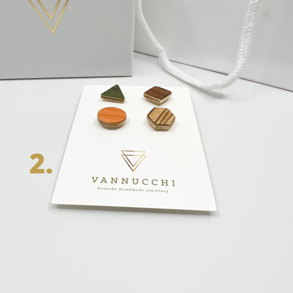 Mix and Match Veneer Pin Set two, four geometric shaped wood pins, with orange, olive green, brown and light brown stripe veneers. Displayed on white Vannucchi backing card.