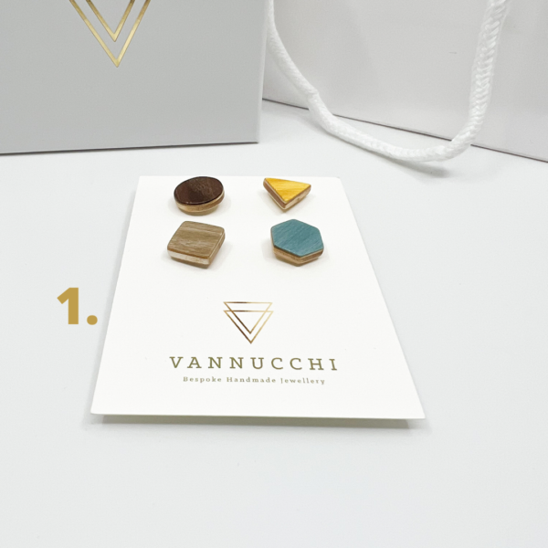 Mix and Match Veneer Pin Set one, four geometric shaped wood pins, with dark brown, yellow, grey and light blue veneers. Displayed on white Vannucchi backing card.