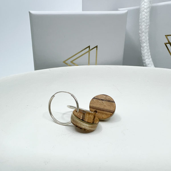 Stripey brown Lucy hoops displayed on white dish in front of branded boxes