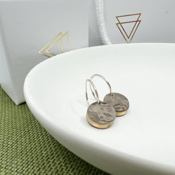 Grey Lucy hoops displayed on white dish in front of branded boxes