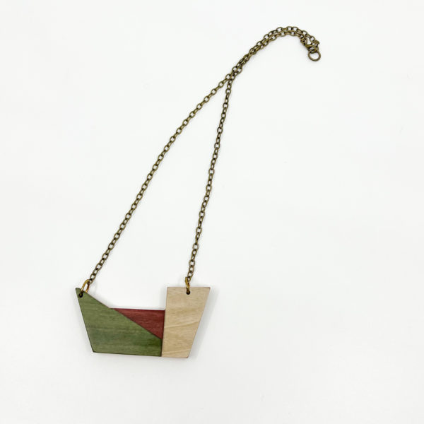 The 'Origini' wood geometric necklace on plain white background. Birds Eye View. Colours of necklace are green, red and white wood veneer.