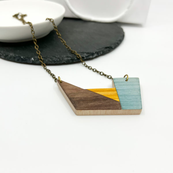 Summer Delight geometric necklace on white background, displayed with white dish laid over slate