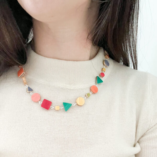 Model wears Collezione XXIII Multi Coloured Dreams Necklace over cream top.