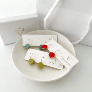 Selection of Collezione XXIII Multi Coloured Dreams Half Hoop Earrings on white dish, on white background with branded packaging.